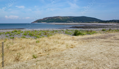 Hills rise rise up behind the stoney beach at Porlock Weir in Somerset  UK