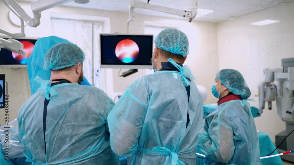Surgeons Performing Operation. Medical team of surgeons in hospital doing minimal invasive surgical interventions Surgeons Performing Operation. Medical team of surgeons in hospital doing minimal invasive surgical interventions