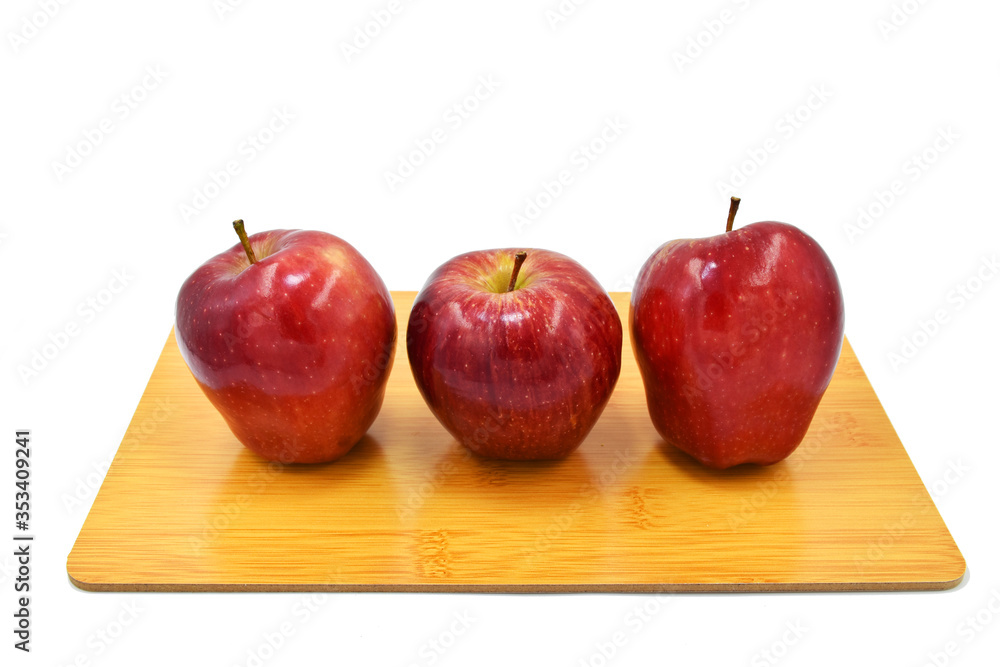three apples isolated place on woodden cutting board. three apples isolated place on woodden cutting board.