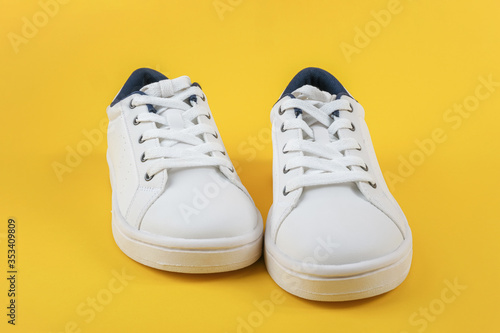 White sports shoes, sneakers with shoelaces on a yellow background. Sport lifestyle concept Top view Flat lay Copy space