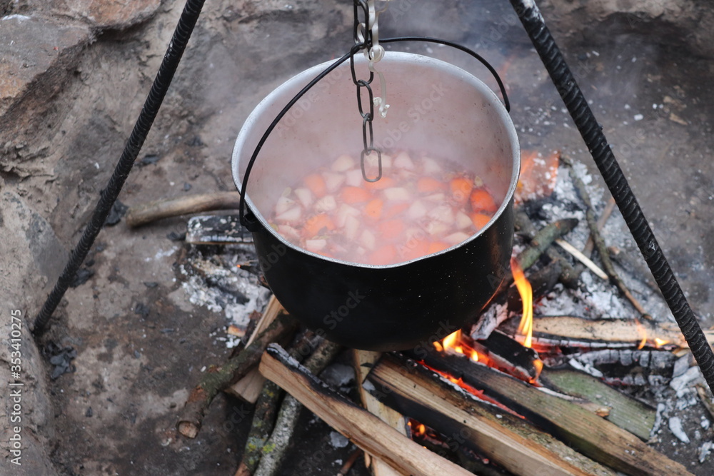 Mulled wine cooked on fire outdoors. Picnic. Romantic getaway near the fire. Mulled wine cooked on fire outdoors. Picnic. Romantic getaway near the fire.