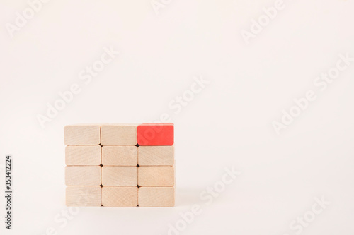 A red wooden block stands out from the crowd. Leadership, Dissent, Diverging Views and Different Concepts