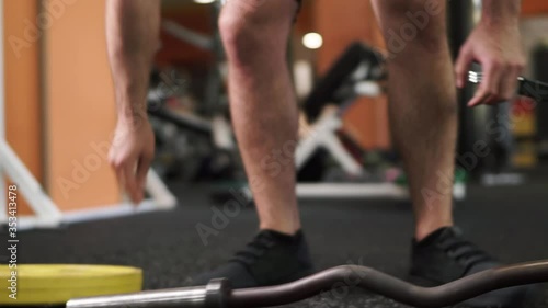 Unrecognizable man Disassembling barbell after exersice