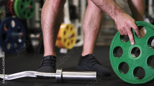Unrecognizable man Disassembling barbell after exersice