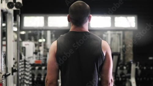 Man doing Standing Barbell Curl Workout. Back view