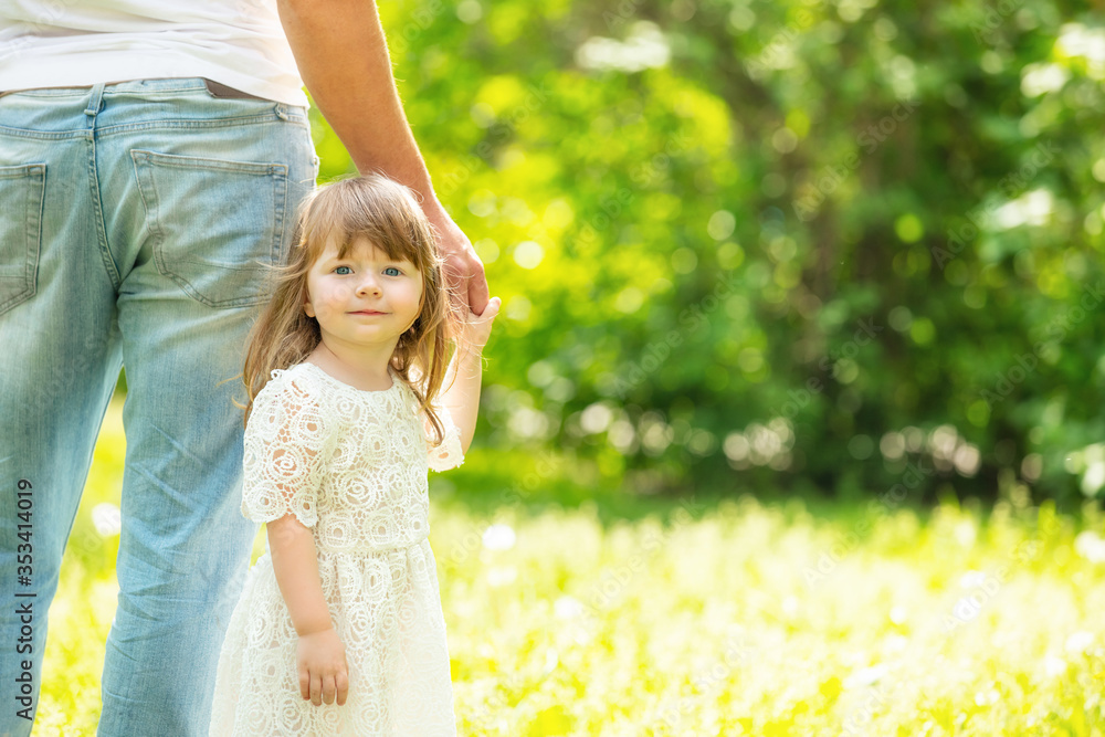 Portrait of a beautiful little girl walking hand in hand with her father close-up Portrait of a beautiful little girl walking hand in hand with her father close-up