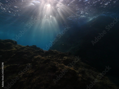 sun beams sun rays and sun shine on rocks underwater