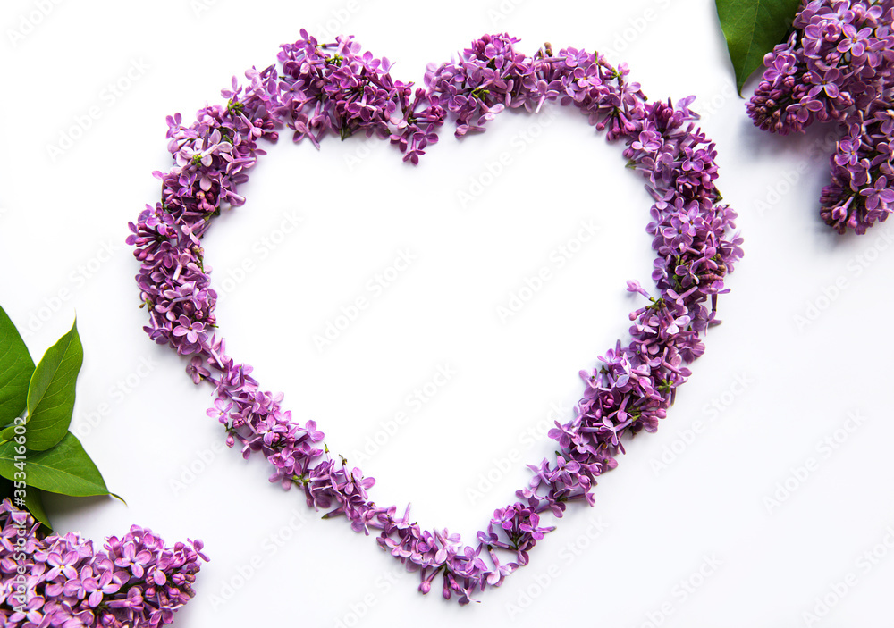 Frame of branches and flowers of lilac in the shape of a heart