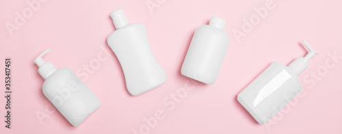 Set of White Cosmetic containers isolated on pink background, top view with copy space. Group of plastic bodycare bottle containers with empty space for you design