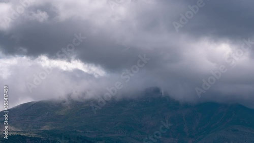 Time lapse: white and gray clouds wisp and cover Panachaikon mountaintop, Greece photo