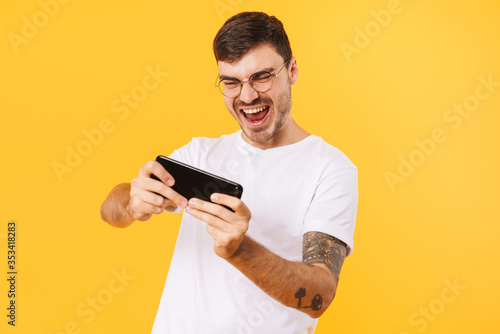 Photo of excited bristle man playing video game on cellphone © Drobot Dean