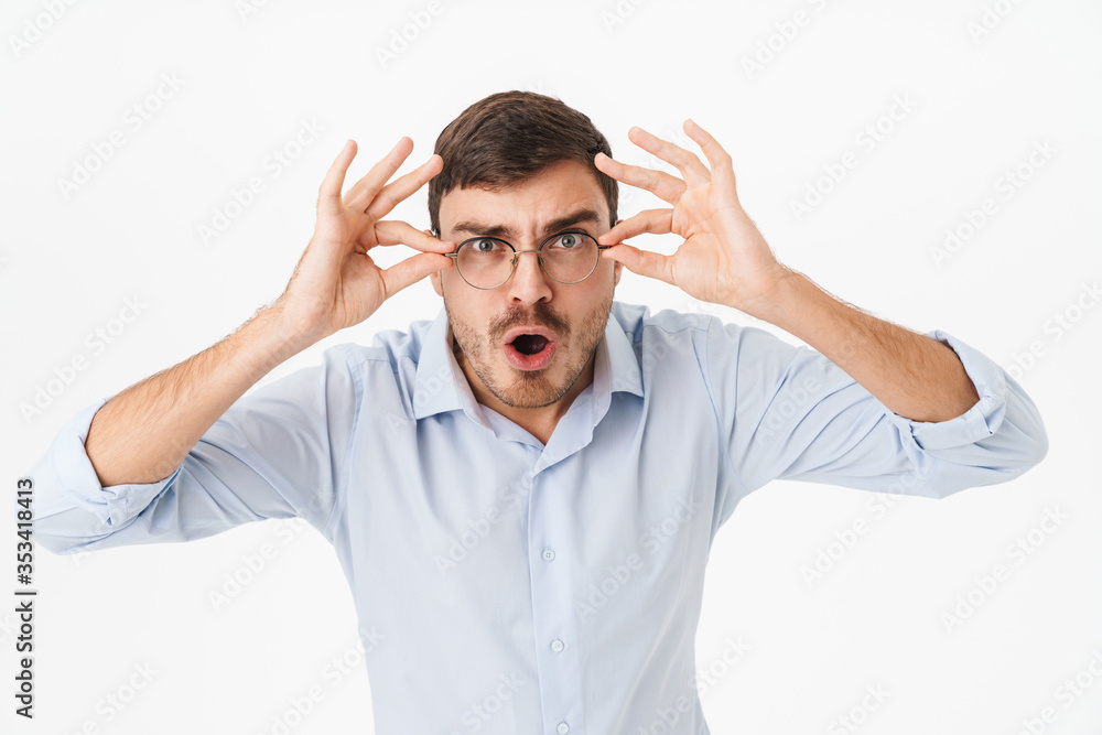 Photo of shocked young man in eyeglasses looking at camera Photo of shocked young man in eyeglasses looking at camera