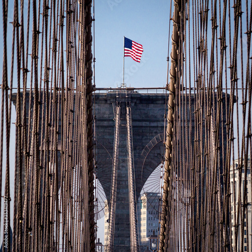 New York City, USA - October 18, 2016: American flag on top of Brooklyn Bridge
