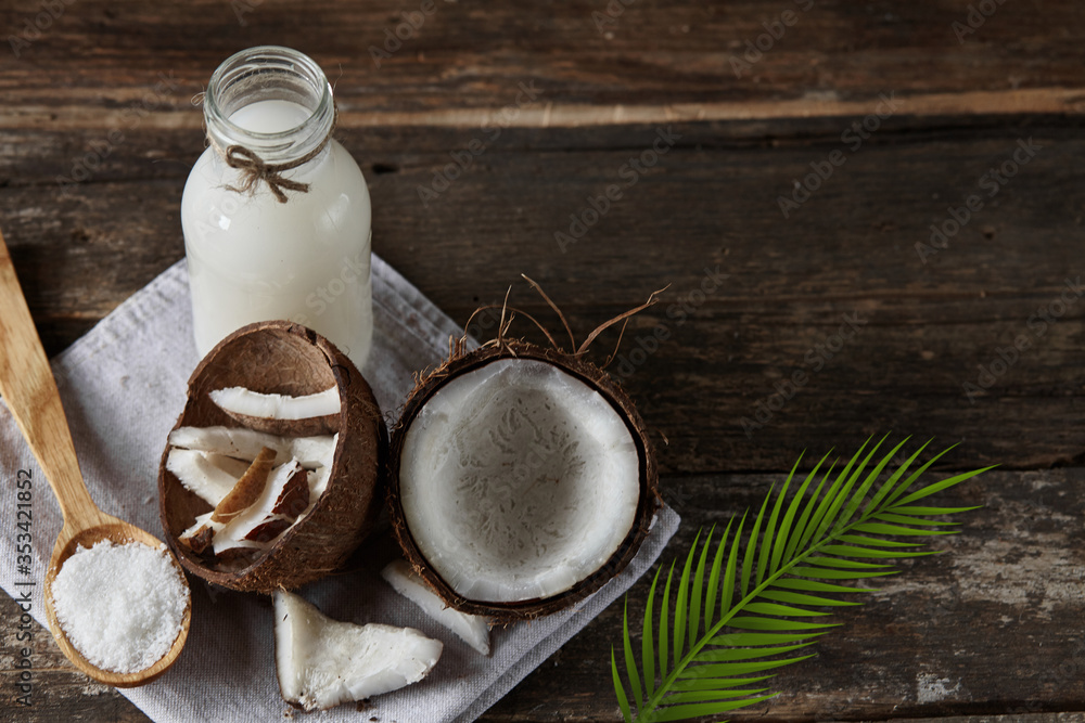 Ripe half cut coconut on a wooden background. Ripe half cut coconut on a wooden background. Coconut cream and oil. Ripe half cut coconut on a wooden background. Ripe half cut coconut on a wooden background. Coconut cream and oil.