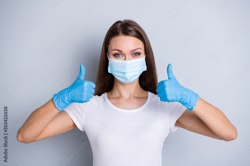Photo of pretty lady keep social distance people contacting had hospital examination healthy person raise thumb fingers up wear protect face medical mask isolated grey color background Photo of pretty lady keep social distance people contacting had hospital examination healthy person raise thumb fingers up wear protect face medical mask isolated grey color background