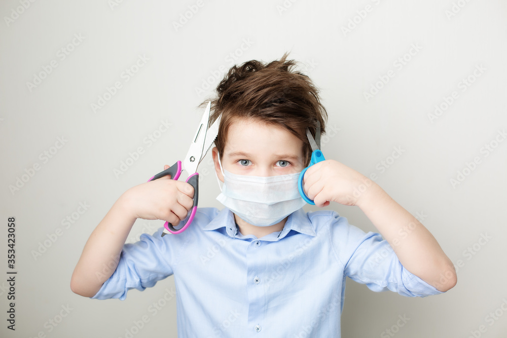 a frightened boy in a medical mask holds a pair of scissors in his hands a frightened boy in a medical mask holds a pair of scissors in his hands