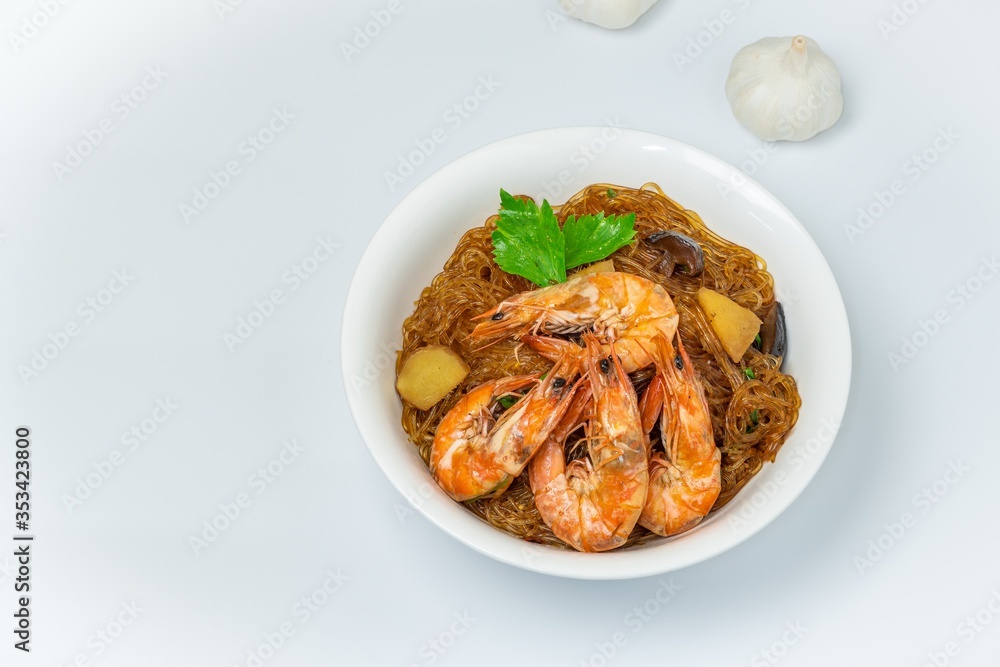 Casseroled shrimps roasted with glass noodles or prawns with Vermicelli Noodles in white blow with chinese celary on the top view. Asian Food Thai fusion style. famous food in Thailand national dish. Casseroled shrimps roasted with glass noodles or prawns with Vermicelli Noodles in white blow with chinese celary on the top view. Asian Food Thai fusion style. famous food in Thailand national dish.
