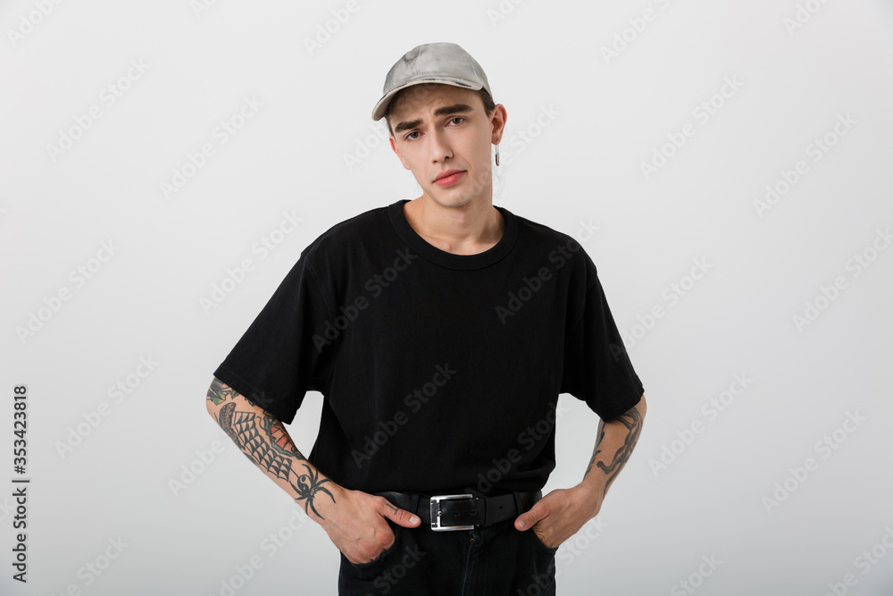 Portrait of confused perplexed man wearing black clothes posing on camera with hands in pockets Portrait of confused perplexed man wearing black clothes posing on camera with hands in pockets