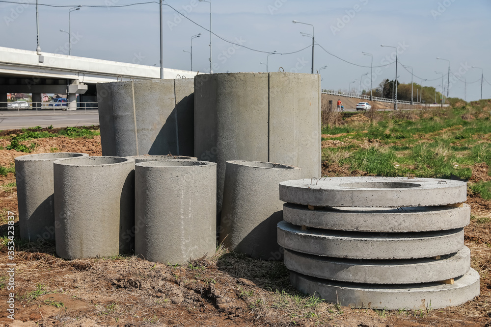 Construction. Pile of concrete slabs and rings in anticipation of building a house. Storage parts of sewerage system on open air