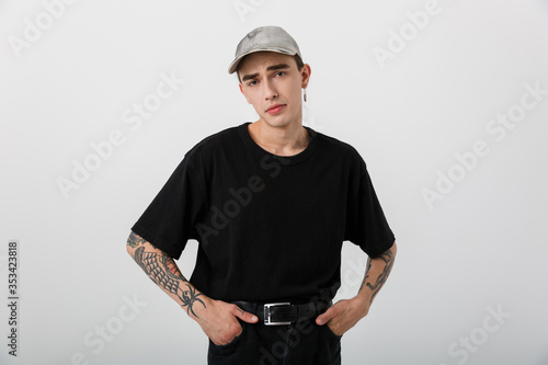 Canvas-taulu Portrait of confused perplexed man wearing black clothes posing on camera with h