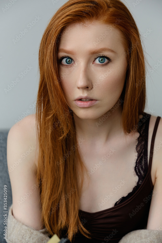 Close portrait of a blue-eyed red-haired girl looking at the camera. Close portrait of a blue-eyed red-haired girl looking at the camera.