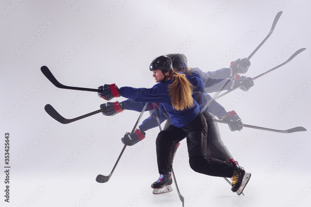 Young female hockey player with the stick on ice court and white background. Sportswoman with equipment training in strobe light. Concept of sport, healthy lifestyle, motion, action, emotions. Young female hockey player with the stick on ice court and white background. Sportswoman with equipment training in strobe light. Concept of sport, healthy lifestyle, motion, action, emotions.