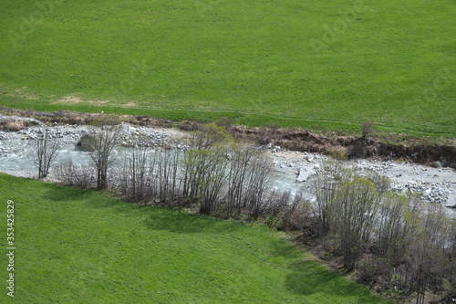 River in the alpine mountains between the meadows. photo