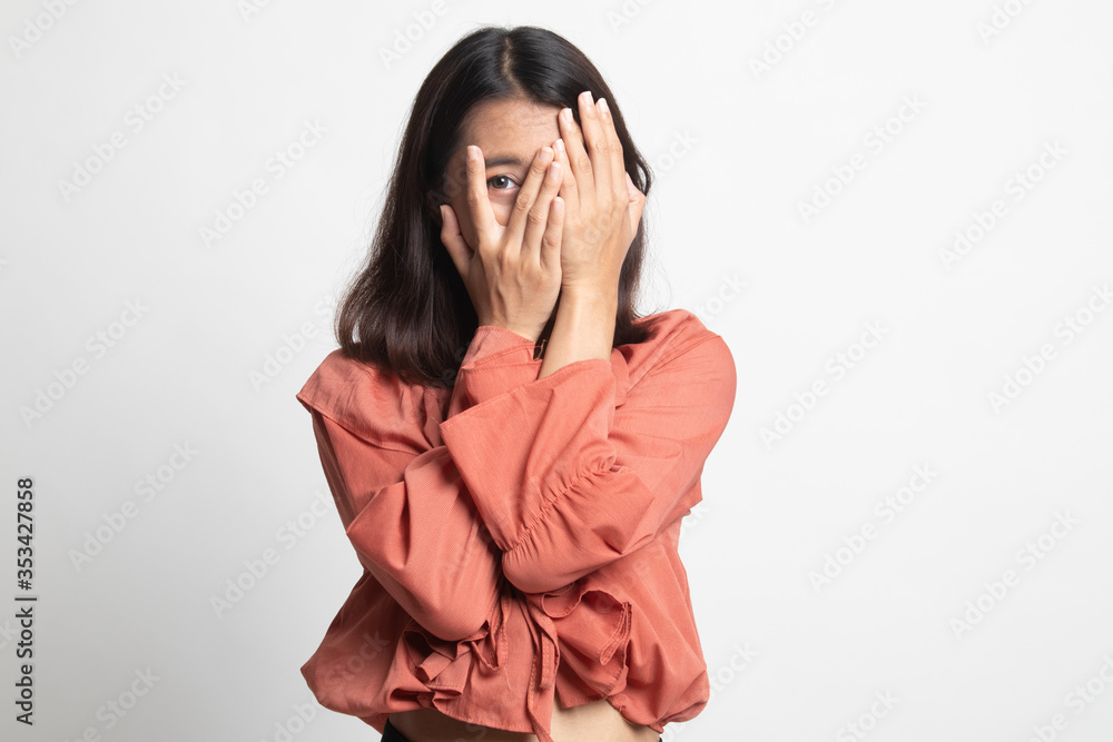 Beautiful young Asian woman peeking through fingers . Beautiful young Asian woman peeking through fingers .
