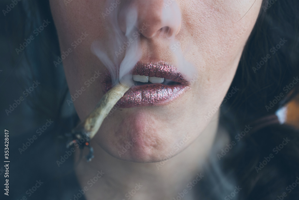 Female lips smoking selfroll weed cigarette. Closeup, lips and fume