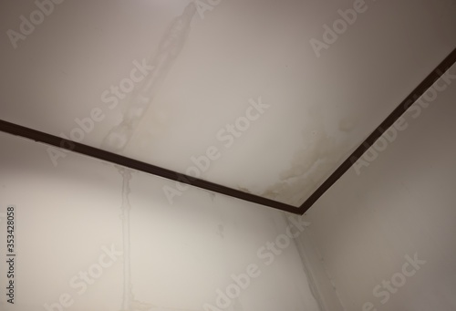 Water marks from the ceiling, water flows from the edge of the ceiling to the wall Moisture from rainwater stains