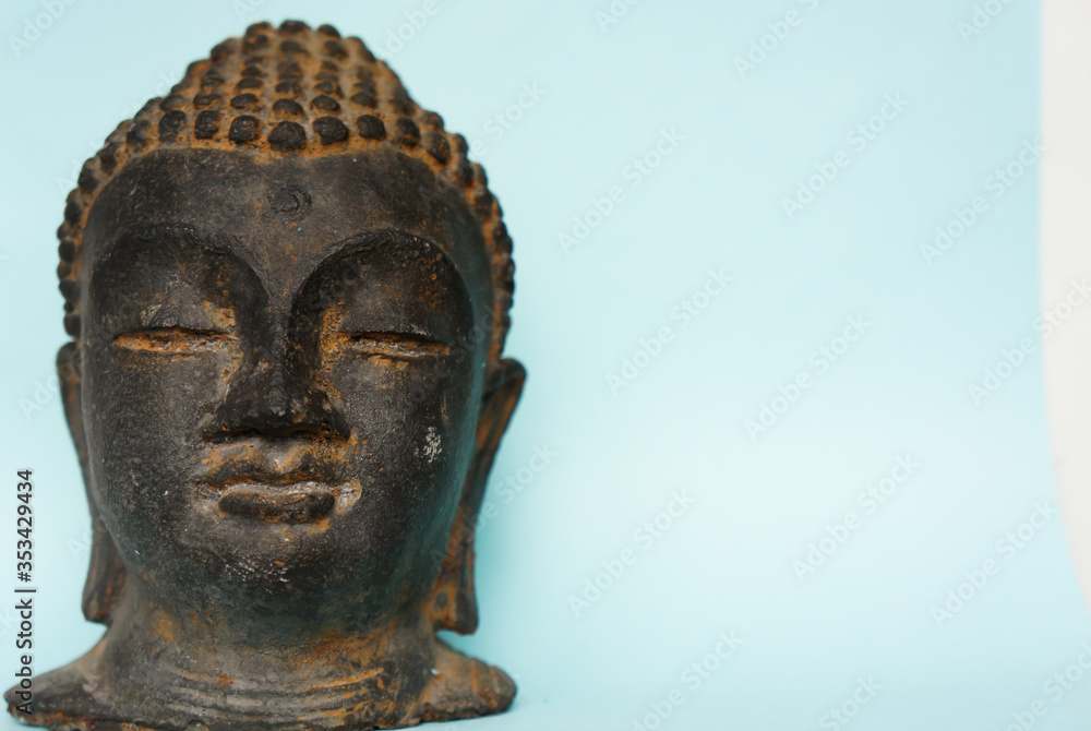 stone buddha head on a blue background with place for your text