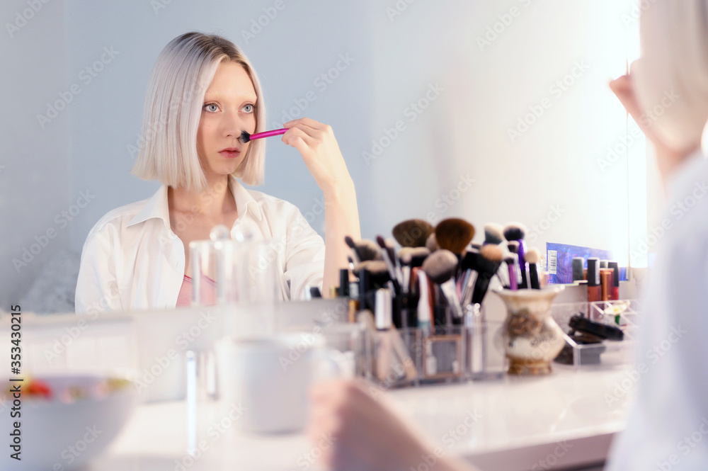 beautiful girl does makeup herself.