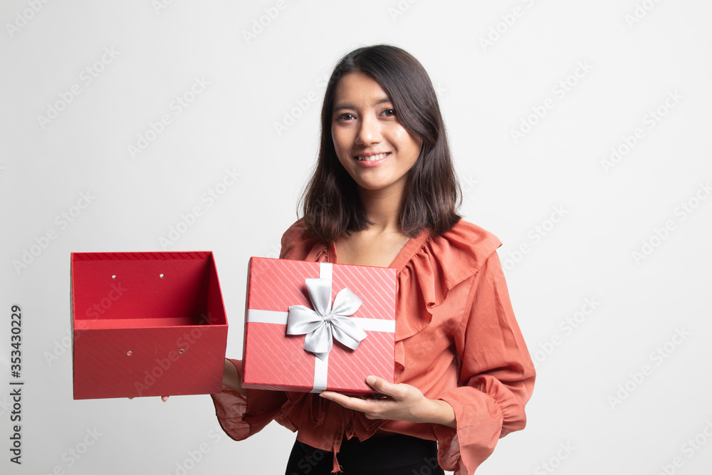 Young Asian woman open a golden gift box . Young Asian woman open a golden gift box .