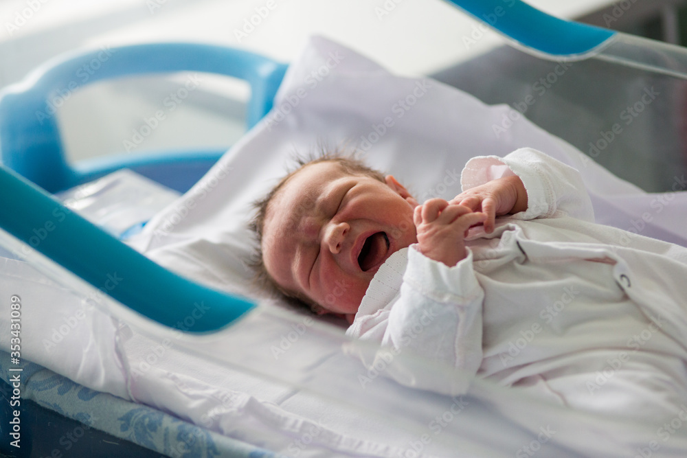 Fototapeta premium Beautiful newborn baby boy, laying in crib in prenatal hospital