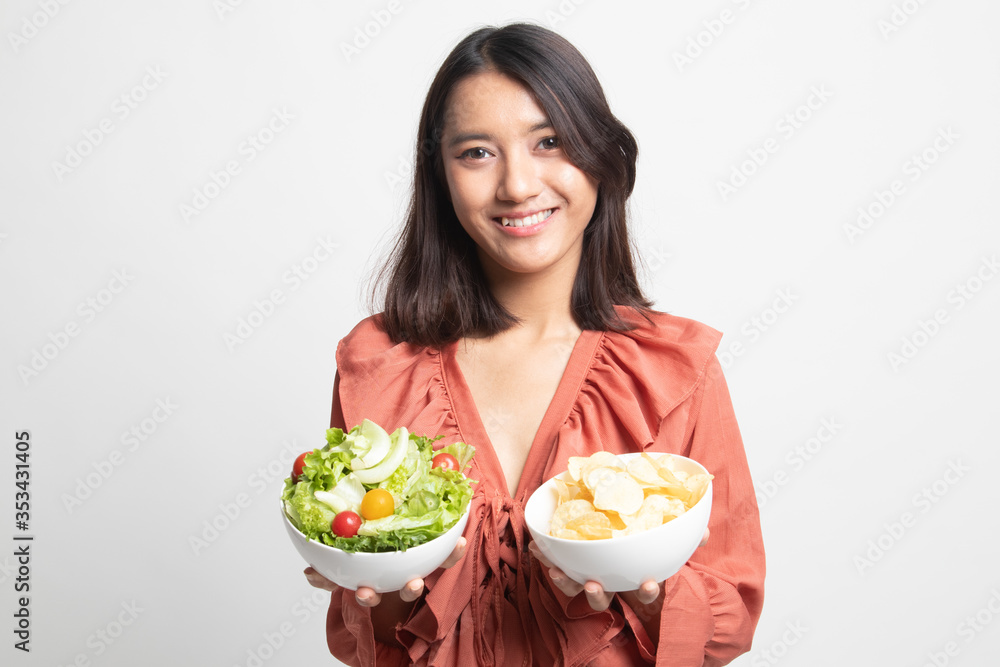 Young Asian woman with potato chips and salad . Young Asian woman with potato chips and salad .