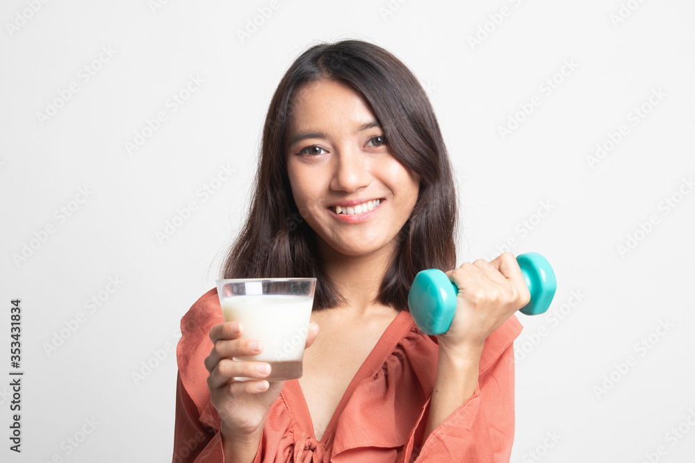Healthy Asian woman drinking a glass of milk and dumbbell . Healthy Asian woman drinking a glass of milk and dumbbell .
