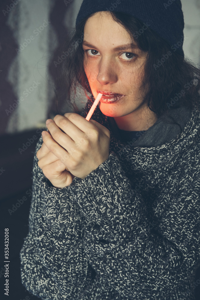 Fototapeta premium Young Female setting fire to cigarette with lighter