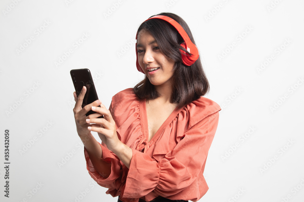 Naklejka premium Pretty asian girl listening music with her headphones .