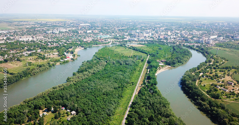 top view of the forest and river. in the background is a city by the river