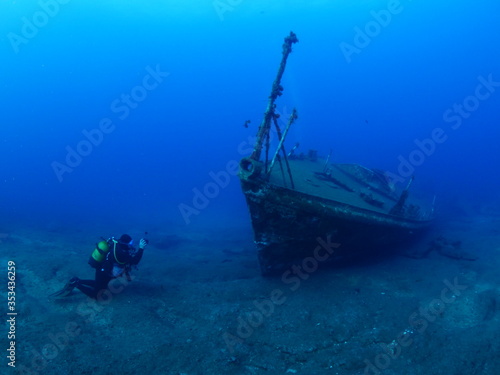 scuba divers exploring ship wreck scenery underwater shipwreck metal on the ocean floor