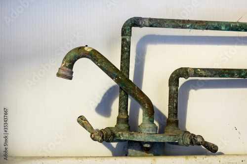 a corroded laundry tub faucet in a grungy basement
