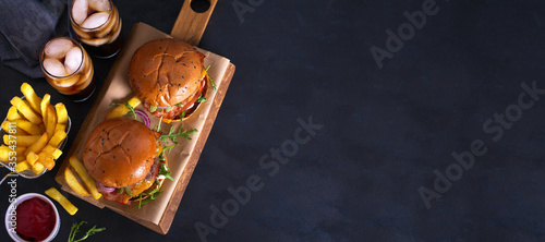 Beef burgers and french fries on serving board. Street food, fast food. View from above, top view. Copy space, banner