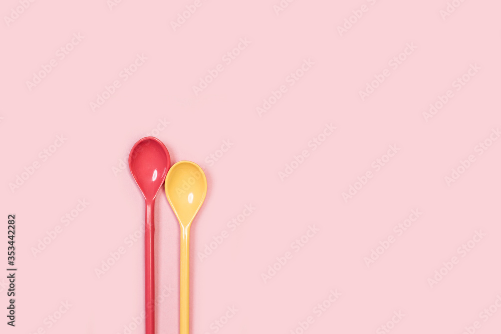 Cucharas de cocina de color rosa y amarilla de plástico sobre fondo rosa aislado. Vista superior. Copy space Cucharas de cocina de color rosa y amarilla de plástico sobre fondo rosa aislado. Vista superior. Copy space
