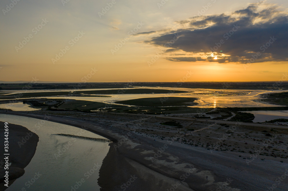 Aerial photo of beautiful sunset over Pagham Nature Reserve with the colours reflecting off the lake.
