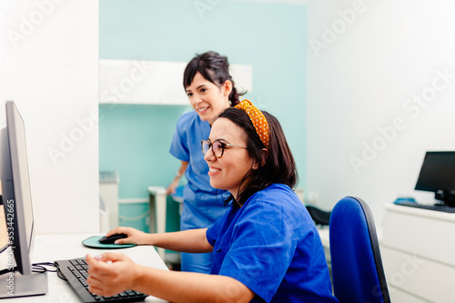 Two nurses using a computer in a x-ray room