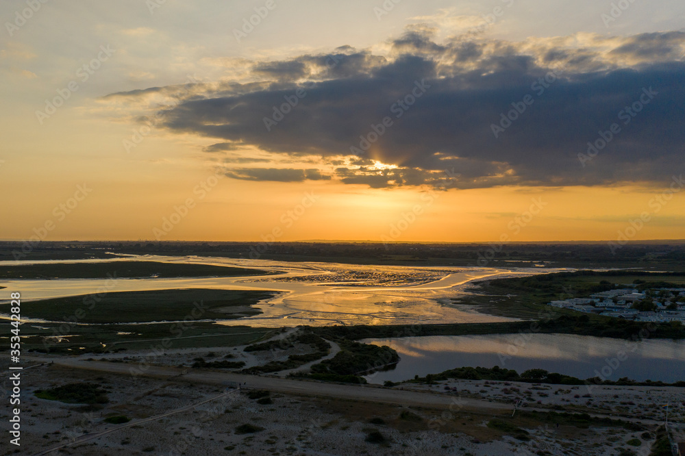 Beautiful sunset over Pagham Nature Reserve with the colours reflecting off the lake. Aerial view.