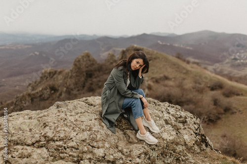 portrait of the young woman sitting on the rocks