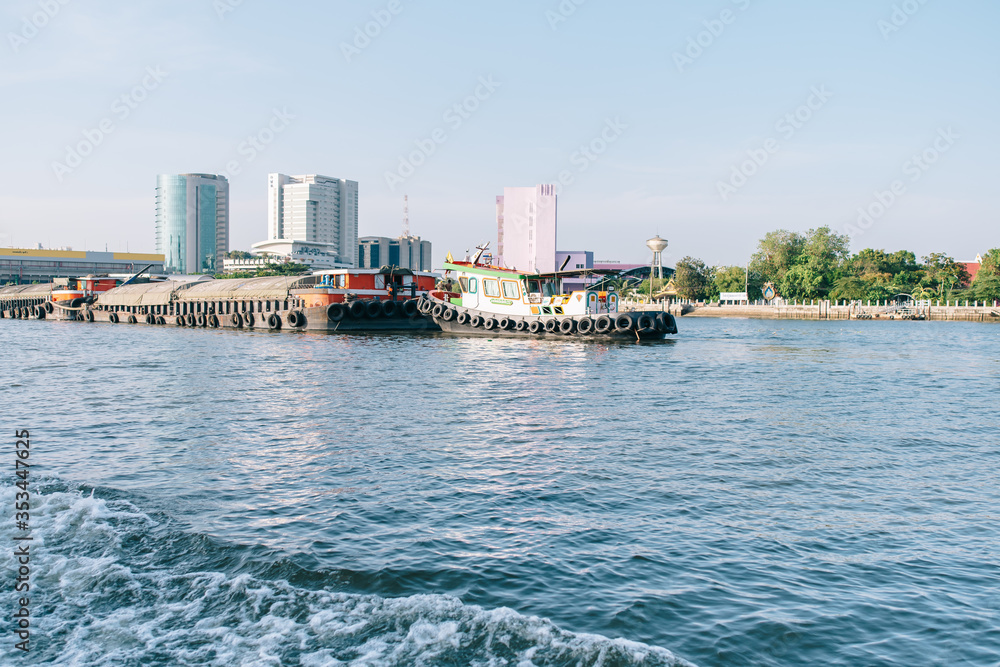 Bangkok, Thailand - 22 may, 2020 : tug boat taking out sand carrier on the Chao Phraya River. Sand carrier.
