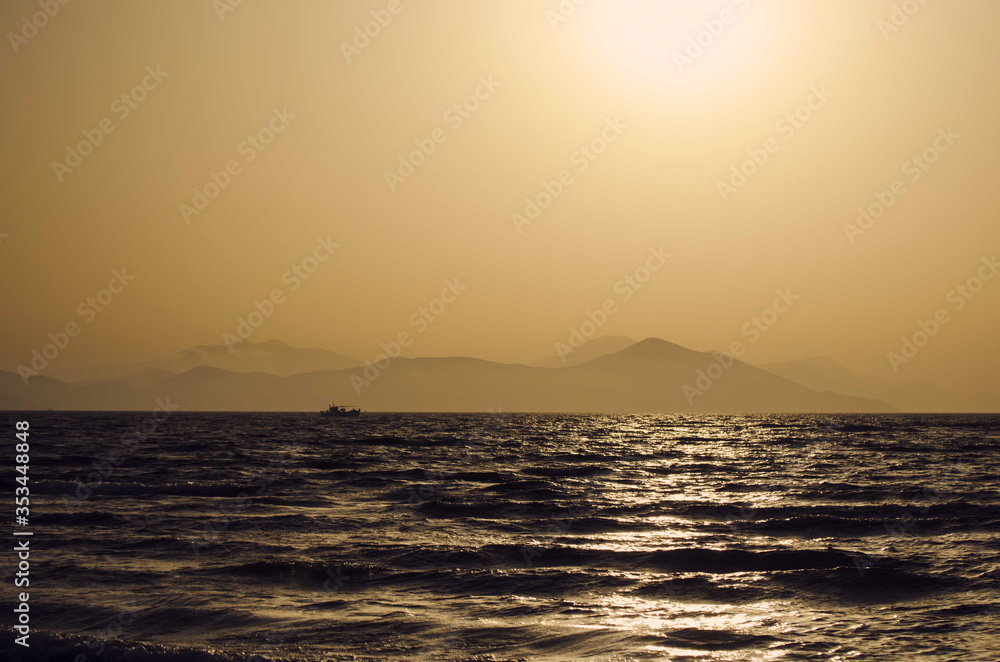 Fototapeta premium sunset over the sea, cloudless, the whole scene is colored in gold and orange