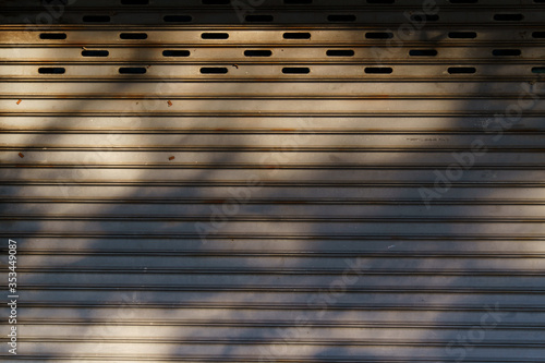 Abstract gray shadow background of tree branch falling on grey metal sheets.